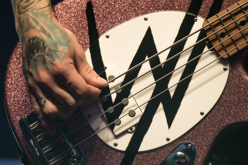 tattooed hand playing guitar